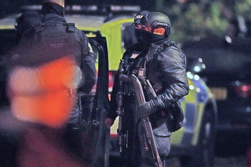 An armed police officer holds a gun outside a home in Rutland Avenue. Three men have been arrested under the Terrorism Act. AP Photo