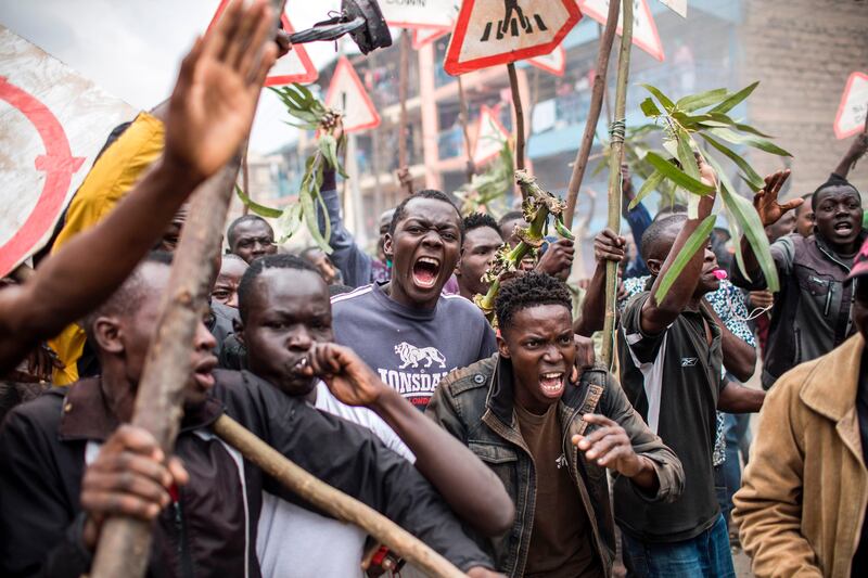 Supporters of the Kenyan opposition presidential candidate shout and hold sticks during a protest in the Mathare slums of Nairobi on August 9, 2017, a day after the presidential election. Luis Tato / AFP