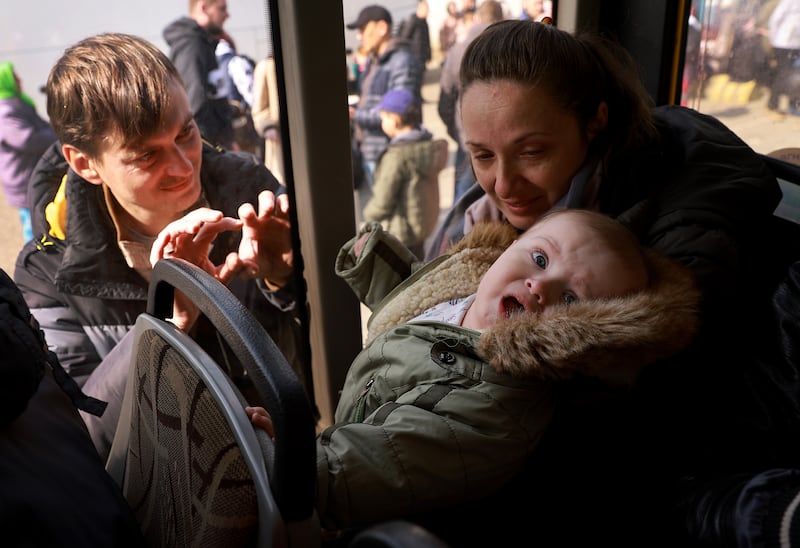 Eugene Grigorash says goodbye to his wife Victoria Grigorash and their seven-month-old son Roman as their bus leaves Lviv on its way to Poland. Getty