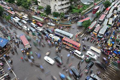 Bangladeshi commuters gather at an intersection in Dhaka on July 23, 2017. - The average traffic speed in Dhaka has dropped from 21km an hour to 7km in the last 10 years, as congestion and unplanned development rises, according to the World Bank. (Photo by Munir UZ ZAMAN / AFP)