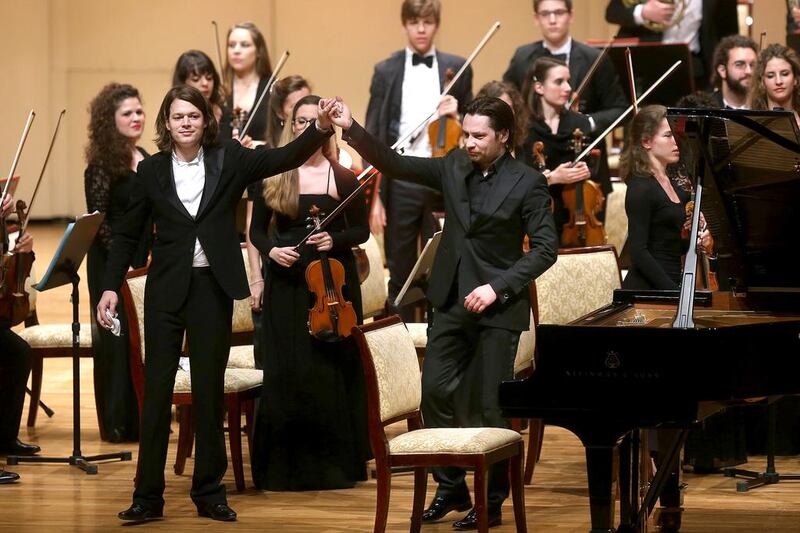 Conductor Mikhail Tatarnikov, right, and French soloist David Fray take a bow after performing with the Orchestra Accademia Teatro alla Scala at Emirates Palace on Tuesday night as part of the Abu Dhabi Classics series. Delores Johnson / The National