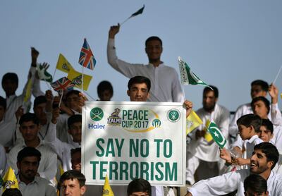 A Pakistani spectator carries a placard denouncing terrorism during a T20 cricket match between Pakistan XI and UK Media XI at the Younis Khan Cricket Stadium in Miranshah, the former stronghold of Al-Qaeda and Taliban militants, in North Waziristan near the Afghan border on September 21, 2017. / AFP PHOTO / AAMIR QURESHI