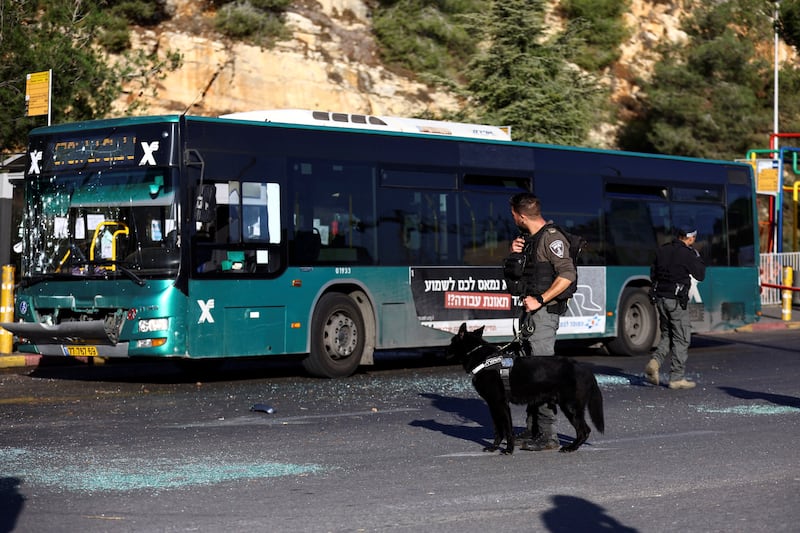 A police canine team at a bus stop in Jerusalem after explosions on November 23. Reuters
