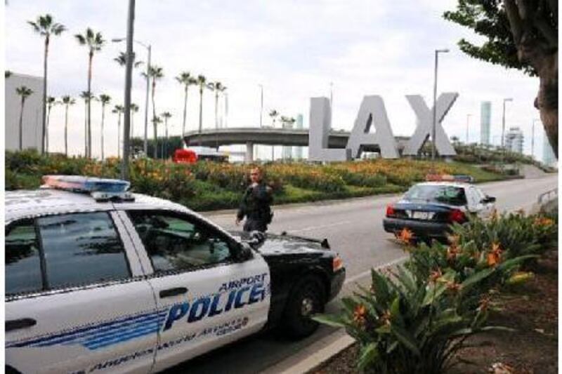 A police officer walks to his patrol car at a security checkpoint near the entrance to Los Angeles International Airport.