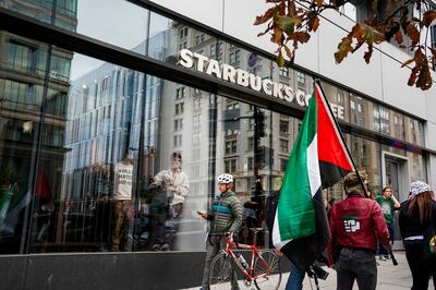 People watch from inside a Starbucks in Washington, as demonstrators march in support of Palestinians in Gaza. Reuters