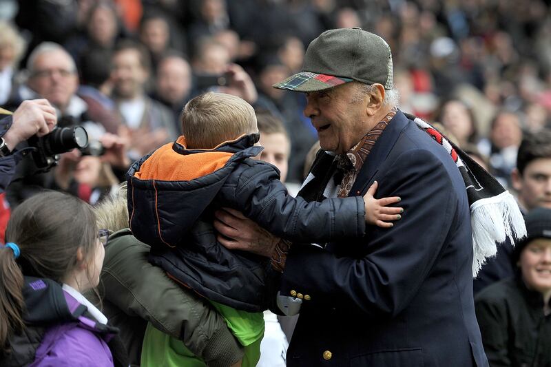 As Fulham FC chairman, Mr Al-Fayed picks up a young fan during a match in London in 2012. Getty Images