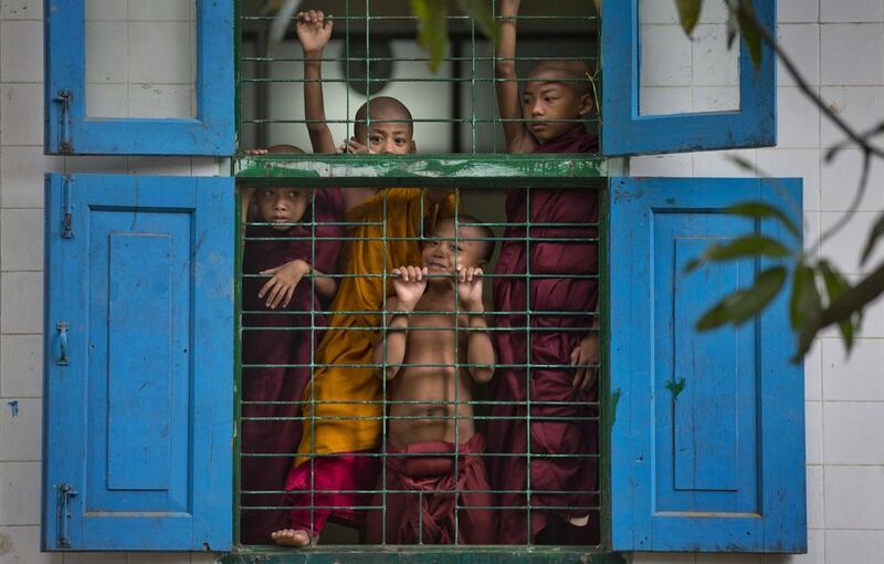 Novice Buddhist monks watch a game of football of fellow monks from a monastery window in Yangon, Myanmar. Myanmar football supporters, including Buddhist monks are gearing up to watch the upcoming World Cup football tournament in Brazil. Gemunu Amarasinghe / AP 