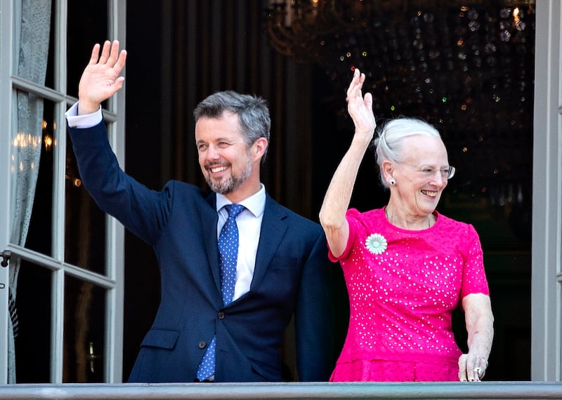 Crown Prince Frederik and Queen Margrethe wave from the balcony at Amalienborg Castle in Copenhagen on the Crown Prince's 50th birthday in May 2018. EPA