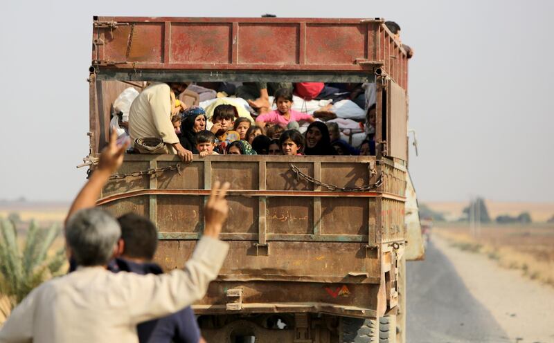 TOPSHOT - Kurdish Syrian civilians flee the town of Kobani on the Turkish border on October 16, 2019 as Turkey and its allies continue their assault on Kurdish-held border towns in northeastern Syria. Turkey rebuffed international pressure to curb its military offensive against Kurdish militants in Syria today as US President Donald Trump dispatched his deputy Mike Pence to Ankara to demand a ceasefire. / AFP / Bakr ALKASEM
