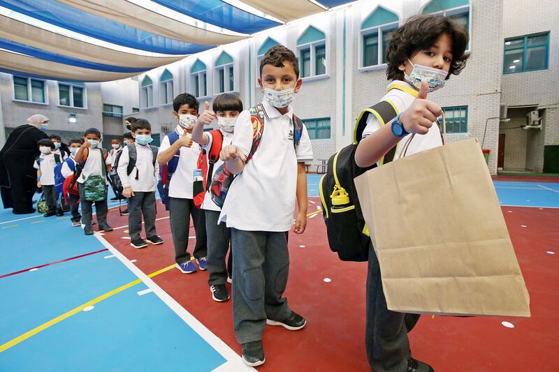 Pupils queue up as in-person classes resume in Kuwait City.