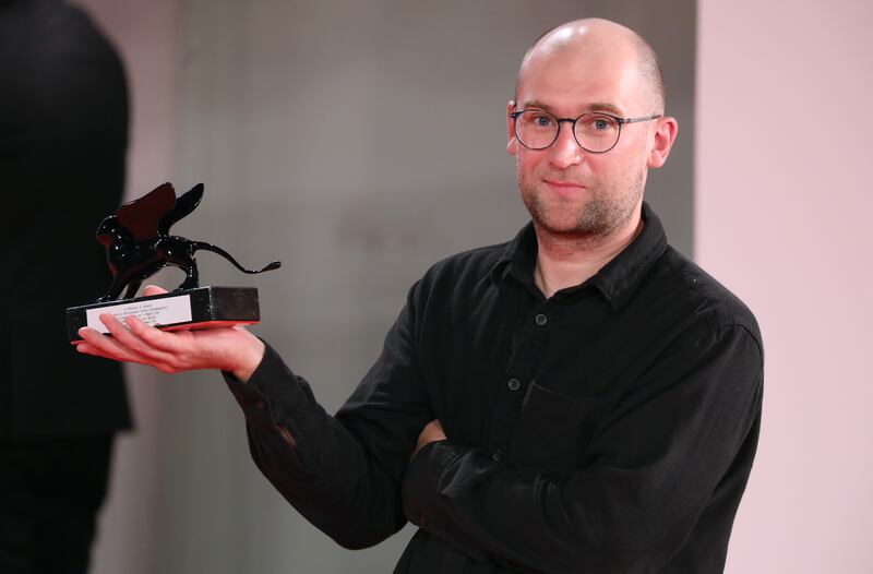 Director Laurynas Bareisa poses with the Orizzonti Award for Best Film for 'Piligrimai' (Pilgrims). Getty Images