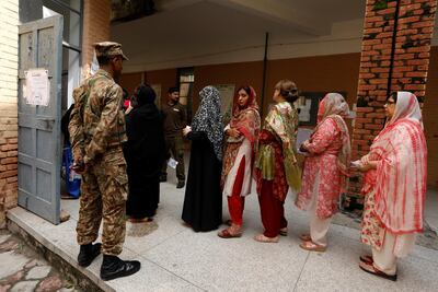 A soldier keeps watch as voters line up to enter at a polling station during general election in Rawalpindi, Pakistan July 25, 2018. REUTERS/Faisal Mahmood