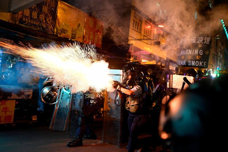 Police personnel fire tear-gas shells to disperse Pro-Democracy protestors in the Sham Shui Po Area of Hong Kong.  AFP