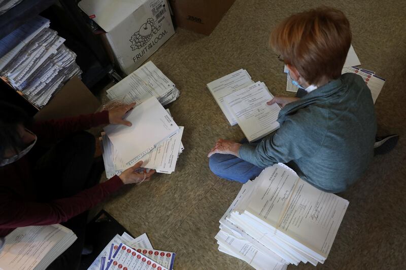 The election specialist Shannon Zastoupil and the election official Pam Hainault sort voter signature books from voting precincts after Election Day at the Kenosha Municipal Building in Kenosha, Wisconsin, U.S. REUTERS