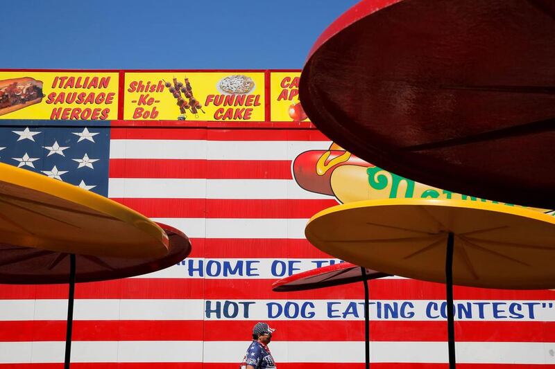 A man dressed in American colours walks through a dining area before Nathan’s Famous Fourth of July International Hot Dog-Eating Contest at Coney Island in Brooklyn, New York. Andrew Kelly / Reuters