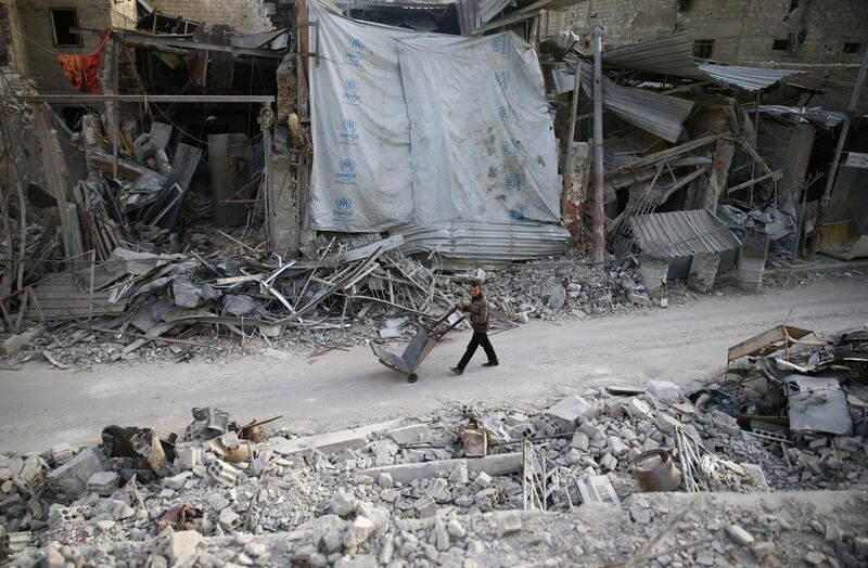 A man pushes a cart past damaged buildings at the besieged town of Douma, Eastern Ghouta, Damascus, Syria on March 5, 2018. Bassam Khabieh / Reuters