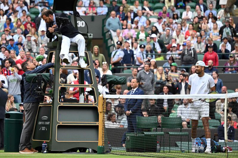 Australia's Nick Kyrgios (R) looks at the umpire talking with an official of the tournament during his men's singles tennis match against Greece's Stefanos Tsitsipas on the sixth day of the 2022 Wimbledon Championships at The All England Tennis Club in Wimbledon, southwest London, on July 2, 2022.  (Photo by Glyn KIRK  /  AFP)  /  RESTRICTED TO EDITORIAL USE