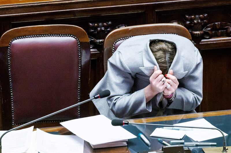Italian Prime Minister Giorgia Meloni hides inside her jacket after opposition politician Angelo Bonelli told her not to give him a 'disturbing look' during a briefing in Parliament. AP