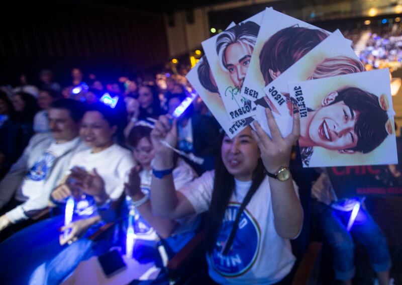 Fans held glow sticks and photos of the band as they cheered them on during their performance.
