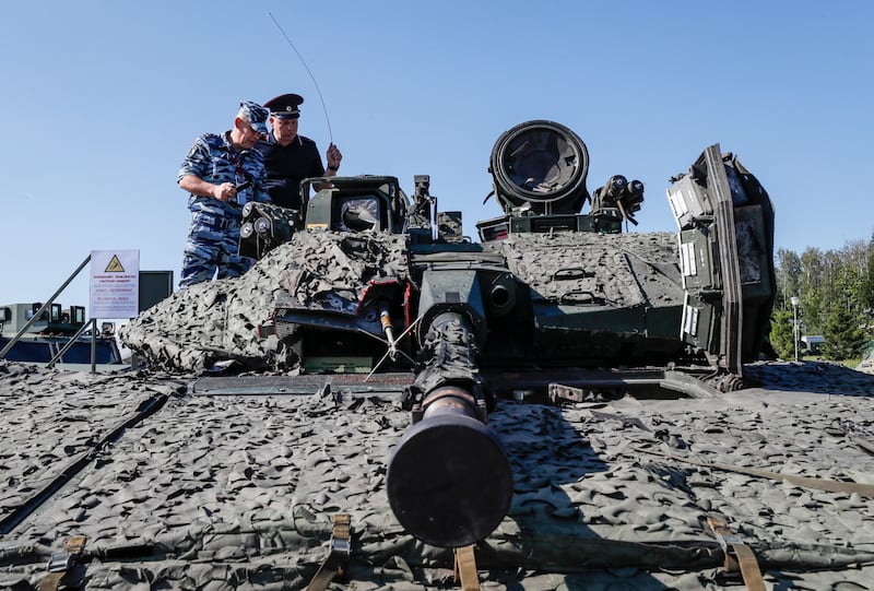 Russian servicemen assess a Swedish infantry fighting vehicle CV90-40
