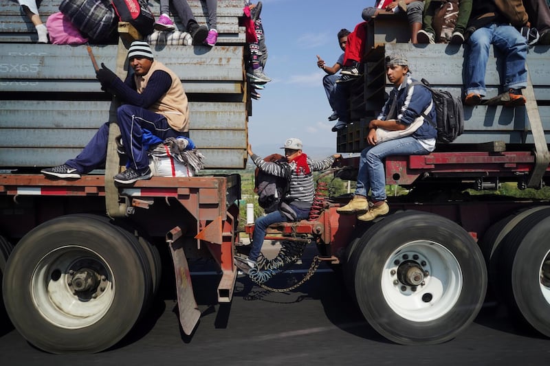 Migrants, part of a caravan of thousands traveling from Central America en route to the United States, travel on top of a truck as they make their way to Irapuato from Queretaro, Mexico. Reuters