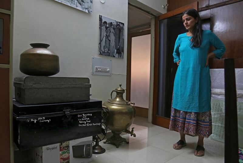 In this July 22, 2017 photograph, CEO of India's new partition museum Mallika Ahluwalia looks at a steel trunk, black, which was among items donated by the relative of a person who had migrated to India during partition in 1947, in New Delhi, India. A new museum on the Partition of the Indian subcontinent opens this week, in the north Indian border city of Amritsar, as the two South Asian giants celebrate seven decades as independent nations. (AP Photo/Altaf Qadri)