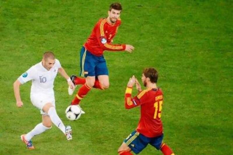 Gerard Pique, centre, and Sergio Ramos, right, will be manning the Spanish defence much the way did against Karim Benzema's France. Jeff Pachoud / AFP