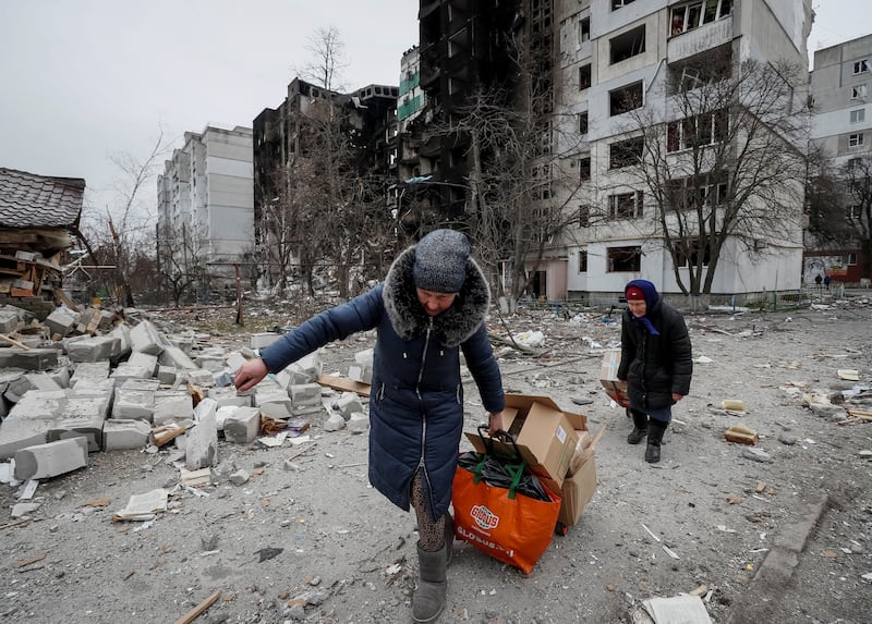 Borodyanka residents carry humanitarian aid packages. Reuters