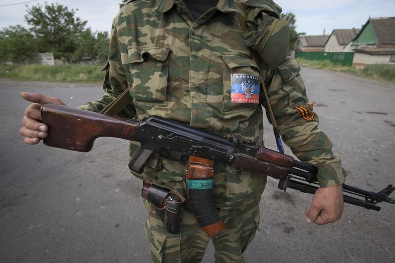 A pro-Russian armed militant with a sticker which reads “Donetsk People Republic” guards a checkpoint blocking the major highway which links Kharkiv, outside Slovyansk, Ukraine. Ukrainians vote Sunday in an early presidential election that could be a crucial step toward resolving the country’s crisis, but separatists in the east are threatening to block the vote. Alexander Zemlianichenko/AP Photo