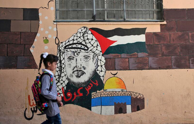 A child walks in front of a mural painting depicting the late Palestinian leader Yasser Arafat in Balata. AFP