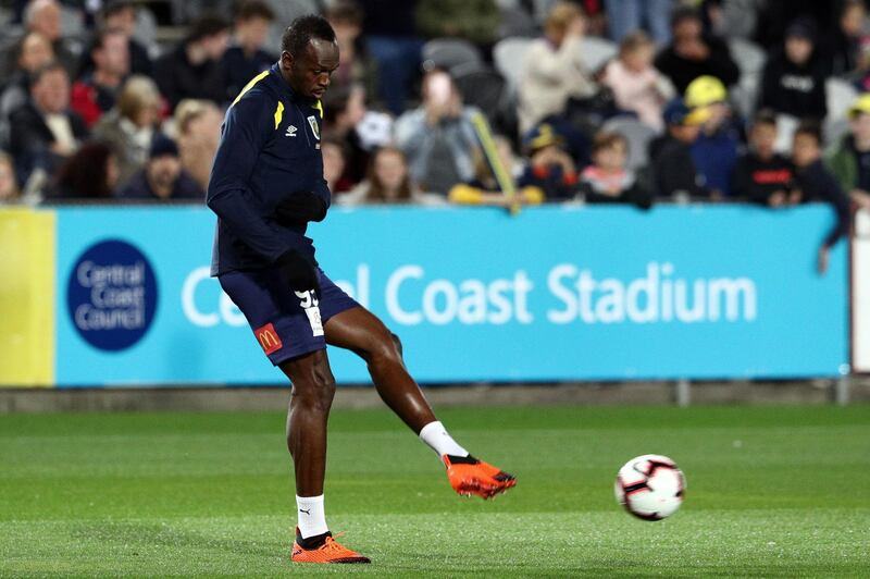 Usain Bolt warms up before making his first appearance for Central Coast Mariners. AFP