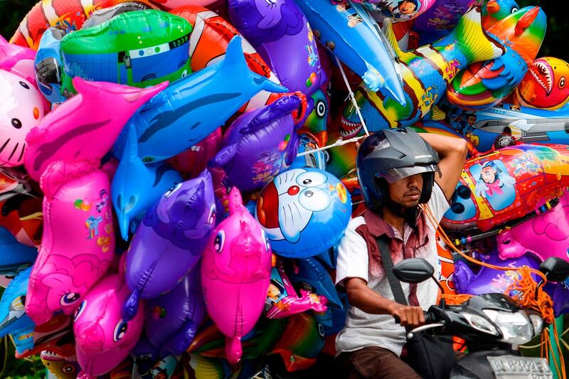 An Indonesian vendor transports ballons on a motorcycle in Banda Aceh. AFP