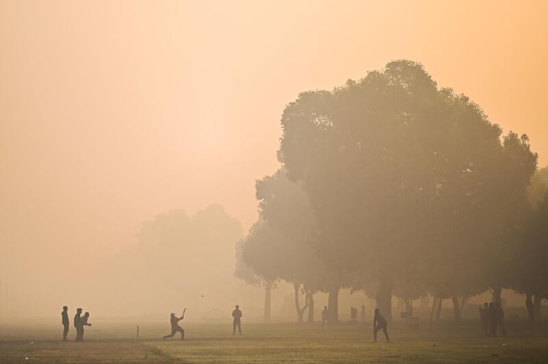 Smog adds atmosphere to a cricket game at a park in New Delhi, the capital of India. AFP