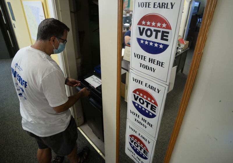 John Gurney, of Brattleboro, casts an early ballot for Tuesday's Vermont primary election. The Brattleboro Reformer / AP