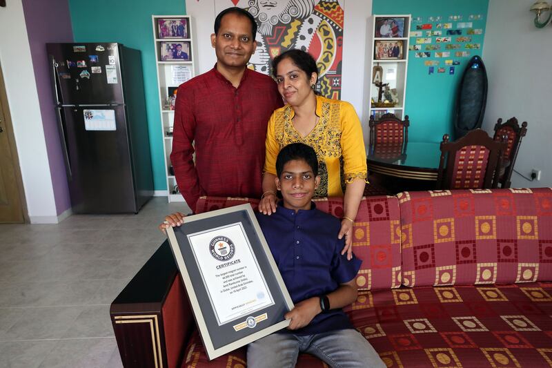 Ramkumar Sarangapani and Mahalakshmi Sankaran with their son Amit, who set the Guinness World Record for using the most magnets to form the number 44. Chris Whiteoak / The National