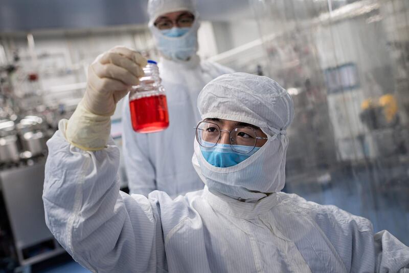 In this picture taken on April 29, 2020, an engineer looks at monkey kidney cells as he make a test on an experimental vaccine for the COVID-19 coronavirus inside the Cells Culture Room laboratory at the Sinovac Biotech facilities in Beijing. Sinovac Biotech, which is conducting one of the four clinical trials that have been authorised in China, has claimed great progress in its research and promising results among monkeys. - 
 / AFP / NICOLAS ASFOURI
