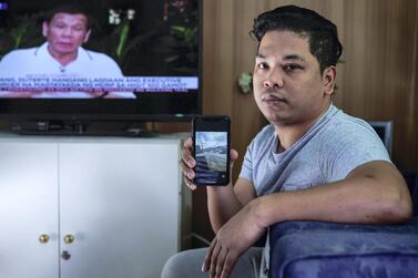 Albert Tenorio, 28, monitors a Filipino news channel from his home in Abu Dhabi. His home town of Talisay, Batangas, which is only around 35 km from the Taal volcano shoreline, has been badly affected by the eruption. Victor Besa / The National 