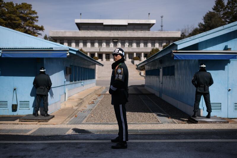 A South Korean soldier, centre, stands guard before the military demarcation line and North Korea's Panmun Hall, in the truce village of Panmunjom. Ed Jones / AFP Photo