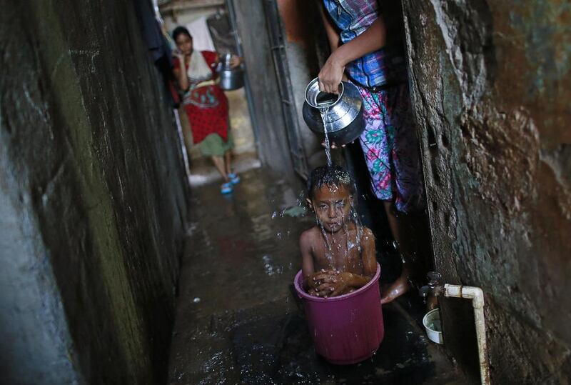 Four-year-old Manjunath takes a bath while sitting inside a bucket outside his house in a slum in Mumbai, India.  Danish Siddiqui / Reuters