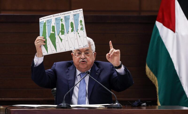TOPSHOT - Palestinian president Mahmud Abbas holds a placard showing maps of (L to R) historical Palestine, the 1947 United Nations partition plan on Palestine, the 1948-1967 borders between the Palestinian territories and Israel, and a map of US President Donald Trump's proposal for a Palestinian state under his new peace plan, as he speaks in the West Bank's Ramallah on September 3, 2020, as he meets by video conference with representatives of Palestinian factions gathered at the Palestinian embassy in Beirut in rare talks on how to respond to such accords and to a Middle East peace plan announced by Washington this year.  / AFP / POOL / Alaa BADARNEH
