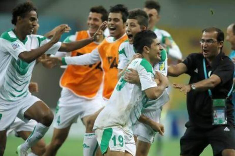 Iraq’s Farhan Shakor, No 19, celebrates with teammates and staff after scoring the decisive penalty in the shootout on Sunday.