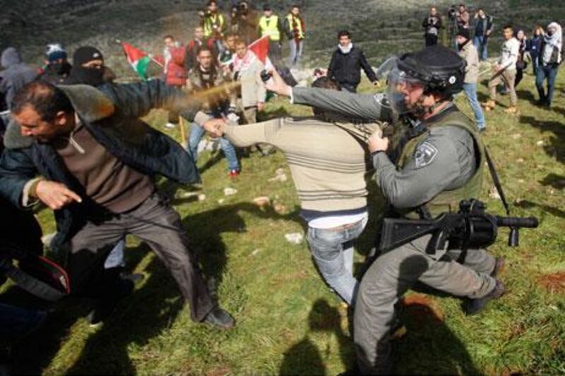 Israeli security forces use pepper spray to disperse Palestinians after the group set up tents and makeshift structures in protest against a nearby Jewish settlement in the West Bank village of Burin on Friday. Mohamad Torokman / Reuters