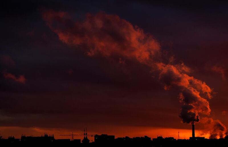 Smoke rises from chimneys during a warm winter evening as the sun sets in Vilnius, Lithuania. AP Photo