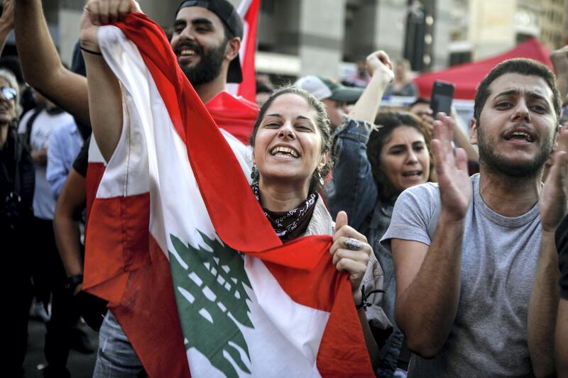 Lebanese anti-government protesters celebrate the resignation of Prime Minister Saad Hariri in Beirut on October 29, 2019 on the 13th day of anti-government protests. (Photo by Patrick BAZ / AFP)