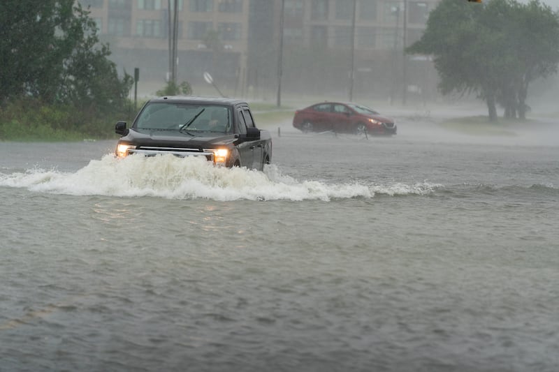 A motorist drives though high water as another turns around during flooding following Hurricane Ian. AP