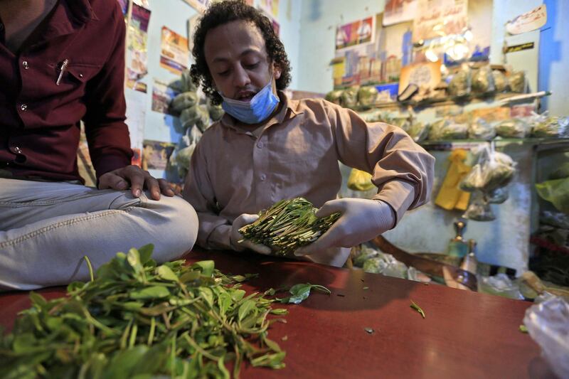 A Yemeni vendor sorts through leaves of qat, the ubiquitous mild narcotic, at a market in the capital Sanaa on May 1, 2020. While most of the world's markets have closed to curb the spread of coronavirus, in Yemen's capital Sanaa, downtown districts selling qat -- the ubiquitous mild narcotic -- still bustle with people. Flouting social distancing rules, Yemenis jostle to select bunches of the chewable leaf from vendors packed into the narrow laneways crowded with stalls. / AFP / Mohammed HUWAIS
