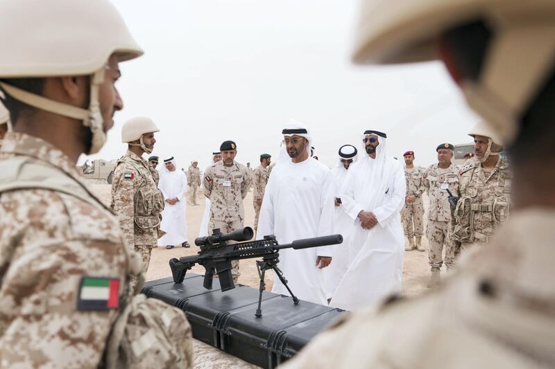 AL DHAFRA REGION, ABU DHABI, UNITED ARAB EMIRATES - April 08, 2018: HH Sheikh Mohamed bin Zayed Al Nahyan Crown Prince of Abu Dhabi Deputy Supreme Commander of the UAE Armed Forces (3rd R), inspects a weapon during a military exercise titled ‘Homat Al Watan 2 (Protectors of the Nation)’, at Al Hamra Camp. Seen with HE Mohamed Ahmad Al Bowardi, UAE Minister of State for Defence Affairs (2nd R) and HH Major General Pilot Sheikh Ahmed bin Tahnoon bin Mohamed Al Nahyan, Chairman of the National and Reserve Service Authority (4th R).

( Rashed Al Mansoori / Crown Prince Court - Abu Dhabi )
---