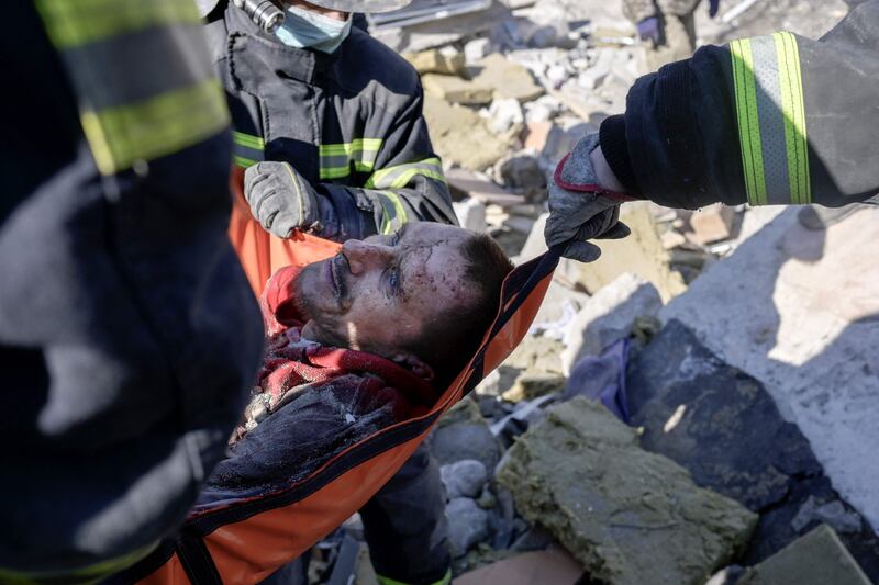 Rescuers carry a Ukrainian soldier from the debris of a military school hit by Russian rockets, in Mykolaiv, southern Ukraine. AFP