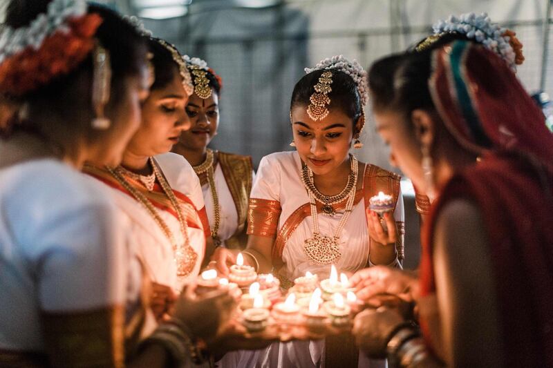 A group of colourful dancers from the Kumari Shiksha Dance Institution light colourful clay lamps in preparation to celebrate Diwali during the two day Diwali (Festival of Lights) Hindu festival celebrations at the old Drive-Inn in Durban, on October 19, 2019. The two-day festival attracts over 100,000 visitors. A billion Hindus worldwide will officially celebrate Diwali on October 27, 2019. AFP