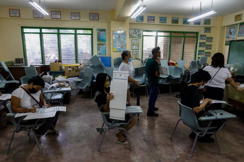 Voters fill in ballots at the voting centre in Cainta. EPA